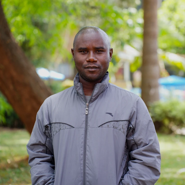 man standing in a park with grey jacket