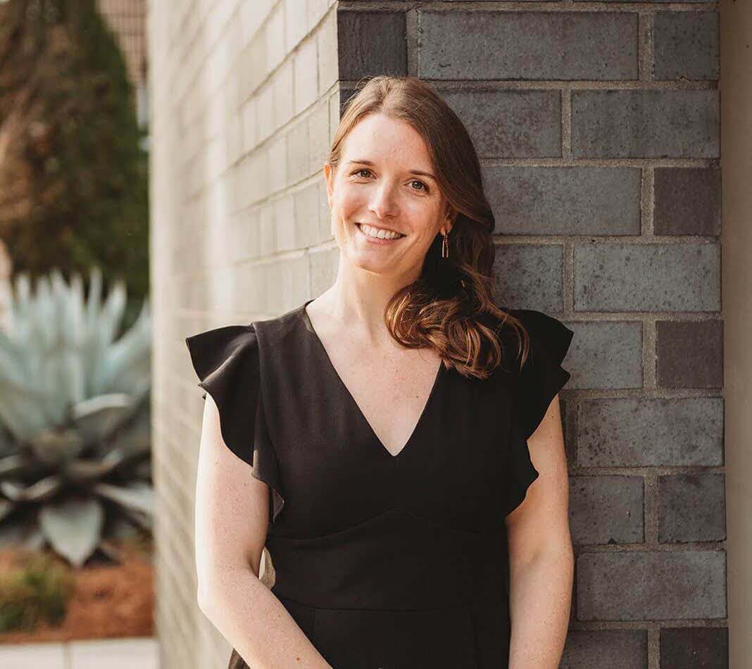 Alexis Brooke Felder a woman in a professional outfit, standing outside, smiling