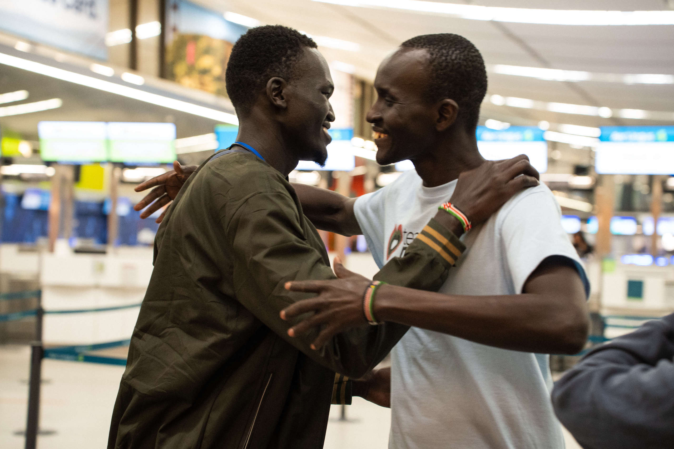 men about to hug at airport