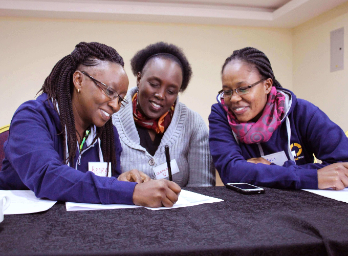 Three RefugePoint team members work at a desk together.