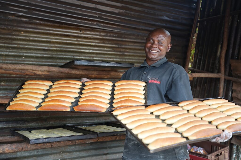 man holding baking pans of food